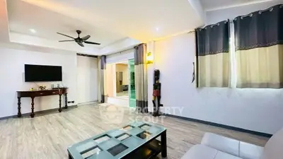 Spacious living room with modern decor and large windows, perfect for relaxation and entertainment.