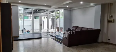 Spacious living room with modern design and large windows opening to patio.