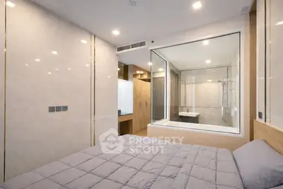 Modern bedroom with glass wall view into luxurious bathroom