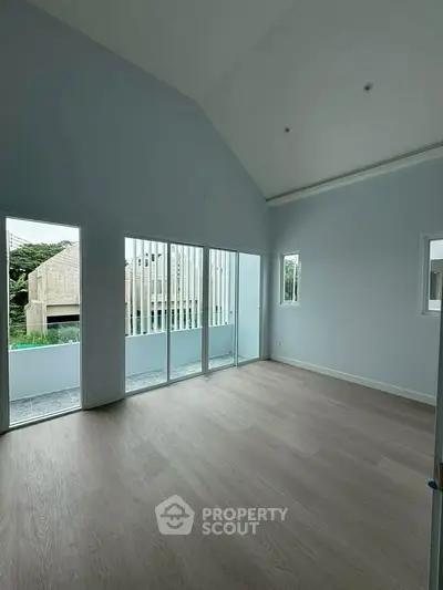 Spacious modern living room with high ceilings and large windows offering natural light and scenic views.