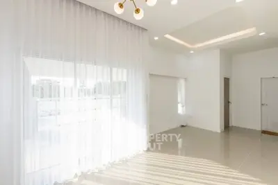 Bright and spacious living room with large windows and modern lighting
