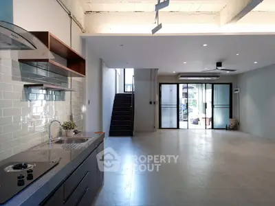 Spacious open-plan living area with modern kitchen and large windows for natural light.