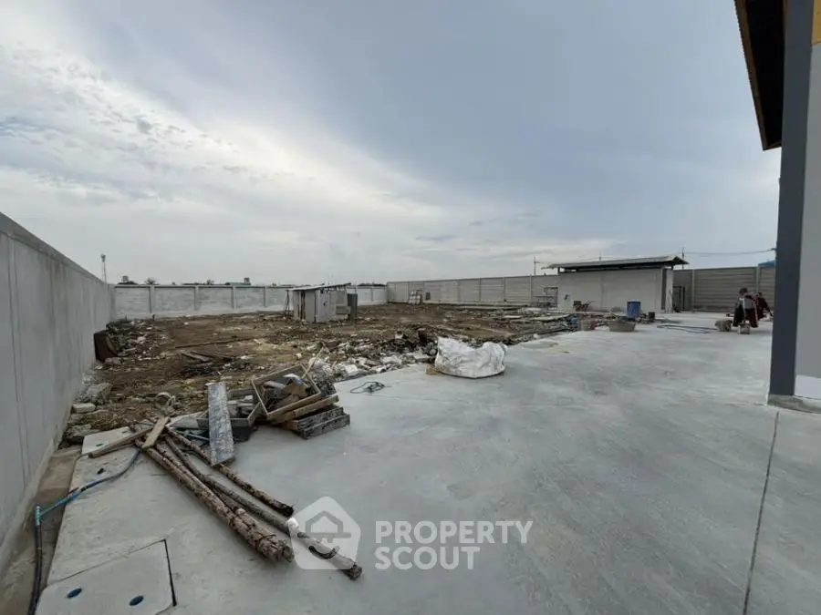 Spacious industrial lot with concrete pavement and boundary walls, ideal for development opportunities.