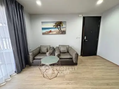 Modern living room with stylish furniture and beach-themed artwork, perfect for relaxation.