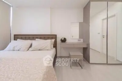 Modern bedroom with elegant decor and mirrored wardrobe in a stylish apartment.
