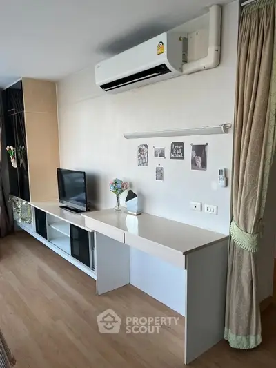 Modern living room with sleek TV unit and air conditioning, perfect for cozy relaxation.