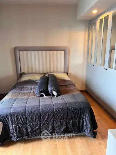 Cozy bedroom with stylish bed and ample closet space, perfect for relaxation and storage.