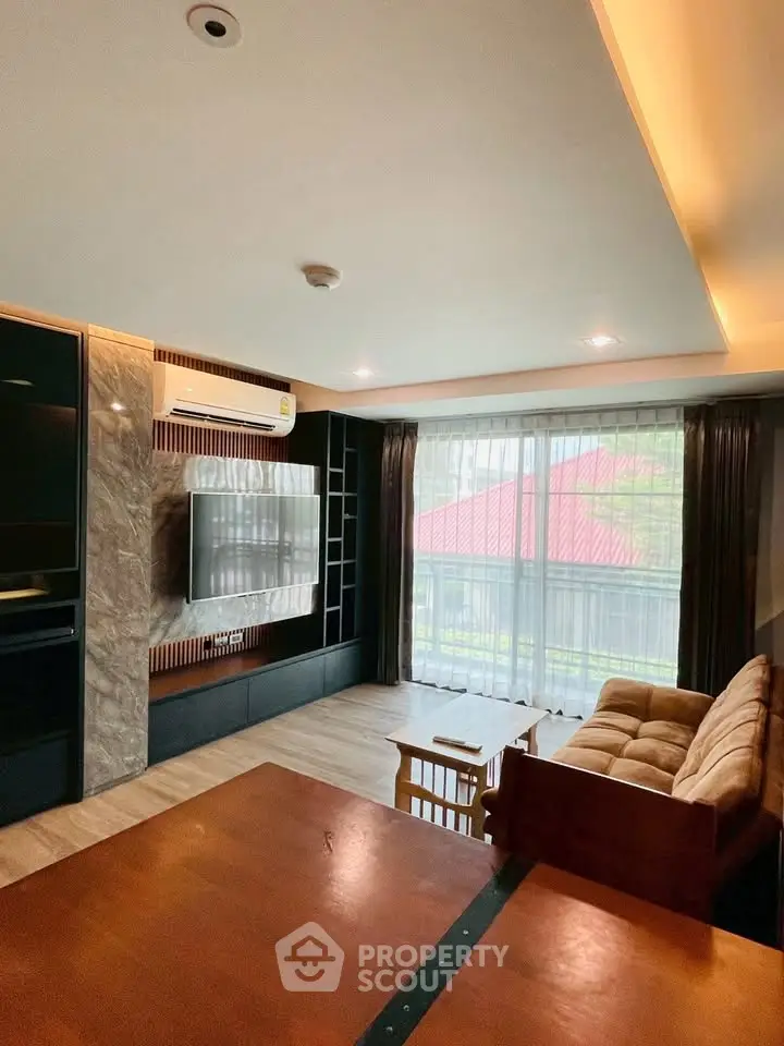 Modern living room with large window and stylish furniture, perfect for relaxation and entertainment.