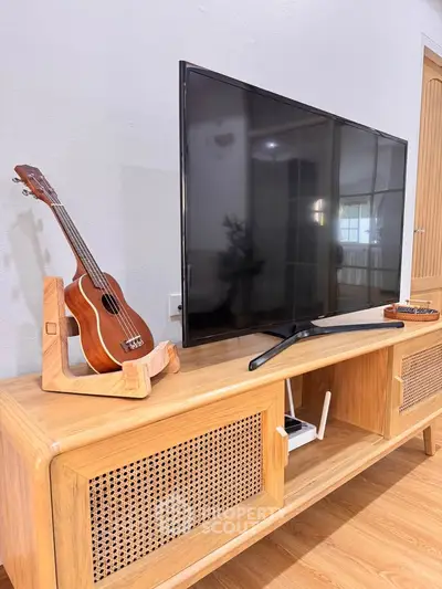Stylish living room with modern TV stand and ukulele, perfect for entertainment and relaxation.