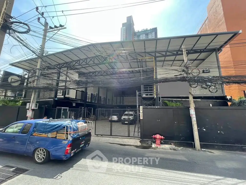 Modern industrial building with spacious parking area and secure gated entrance