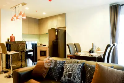 Modern open-layout living room and kitchen with stylish decor and dining area.