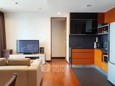 Modern living room with open kitchen, sleek furniture, and hardwood floors in a stylish apartment.