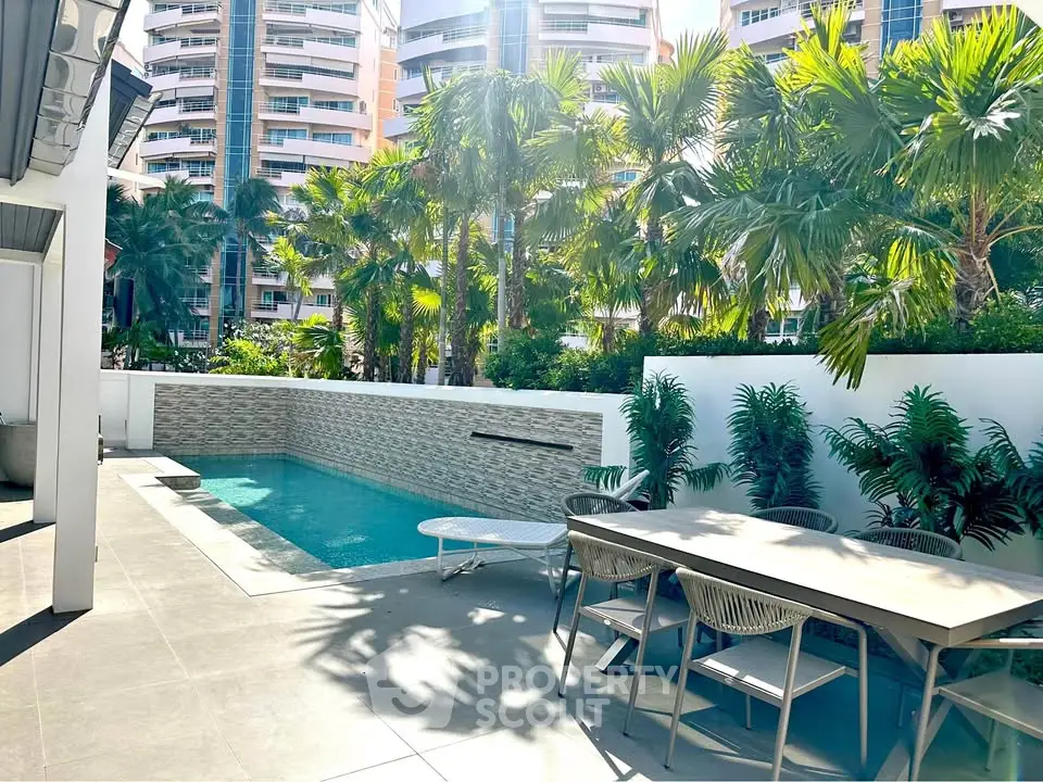 Luxurious private pool area with modern outdoor dining set and lush greenery