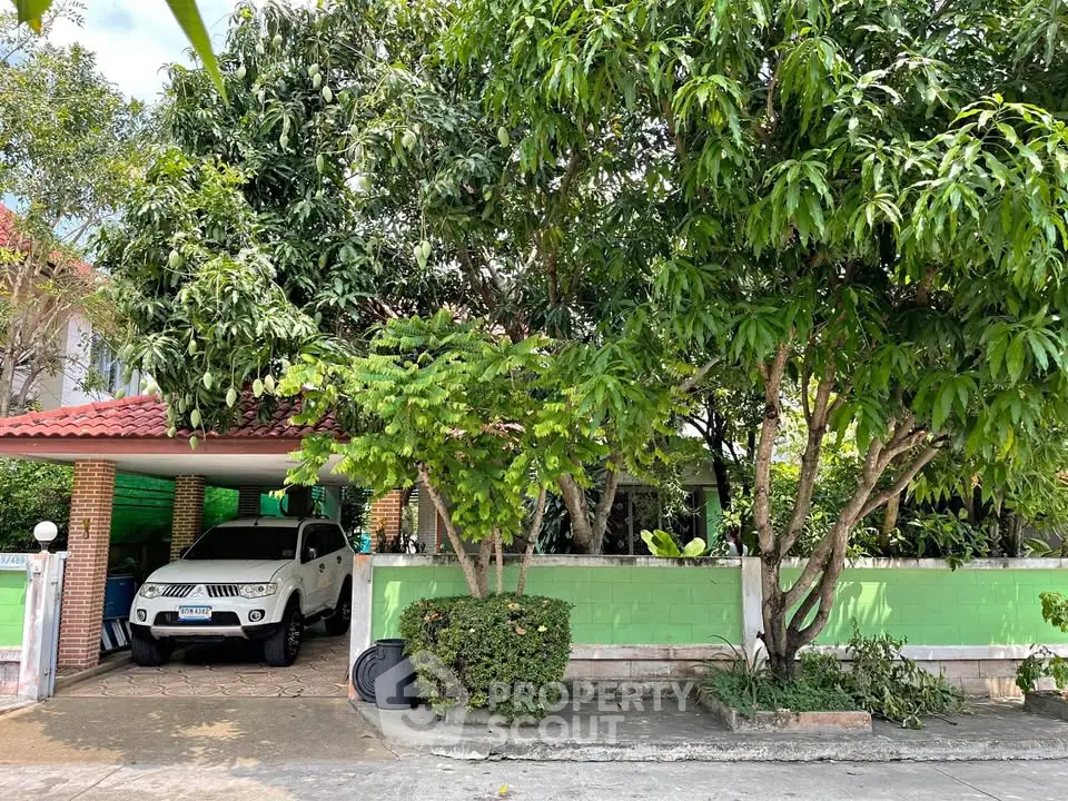 Charming suburban home with lush greenery and covered parking space, perfect for family living.