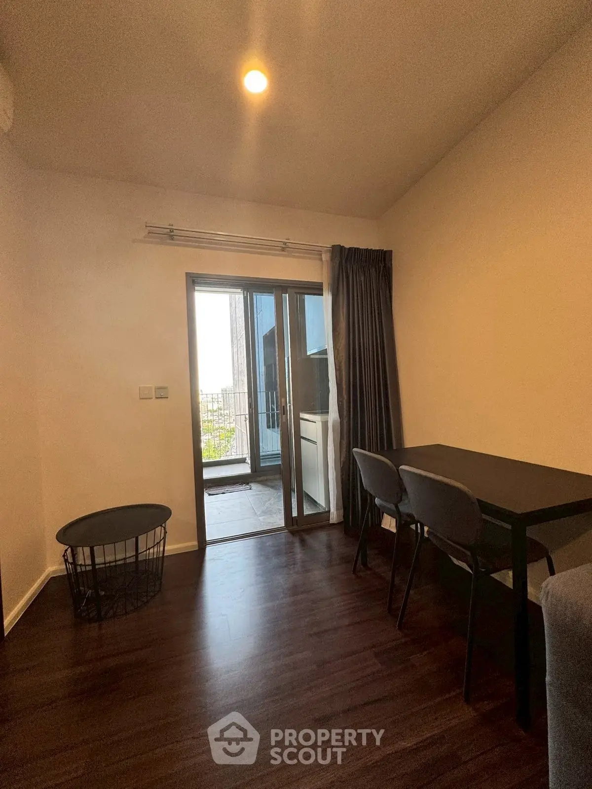 Cozy interior with dark wood flooring and balcony access, ideal for modern living.