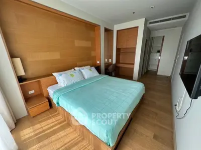 Modern bedroom with wooden accents and natural light, featuring a cozy bed and sleek design.