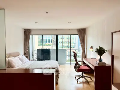Spacious bedroom with balcony and city view, featuring modern furniture and natural light.