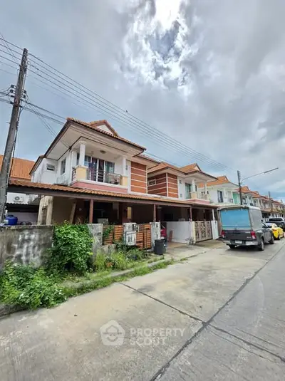 Charming suburban townhouse with red-tiled roof and spacious driveway, perfect for family living.