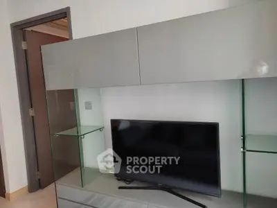 Modern living room with sleek TV unit and glass shelves, perfect for contemporary homes.
