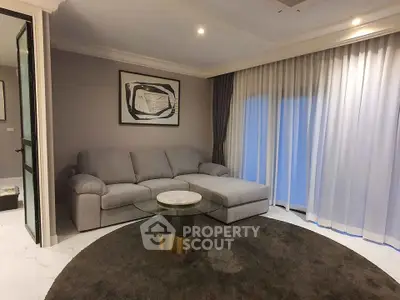 Modern living room with stylish gray sofa and elegant glass coffee table.