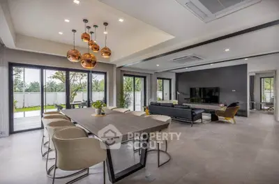 Luxurious open-plan living room with modern dining area and stylish lighting in a contemporary home.