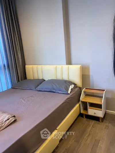 Modern bedroom with stylish bed and nightstand, featuring elegant decor and cozy ambiance.