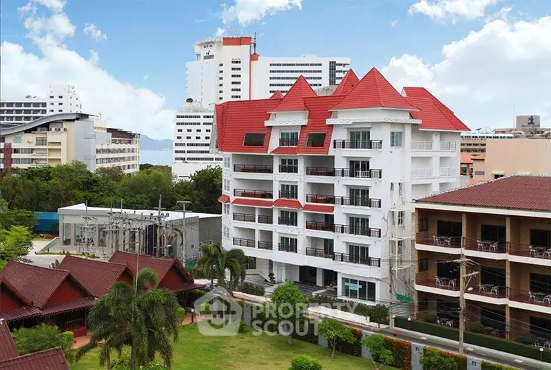 Stunning view of modern apartment building with red roof and lush surroundings
