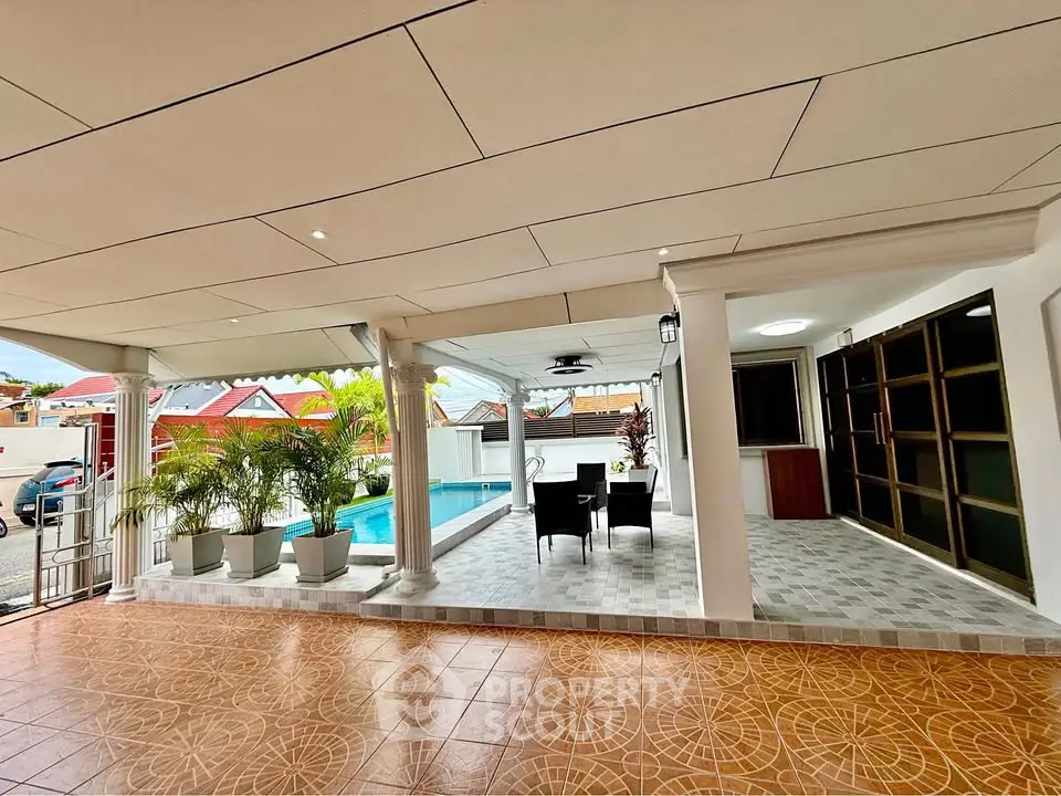 Spacious covered patio with pool view and stylish outdoor seating area.