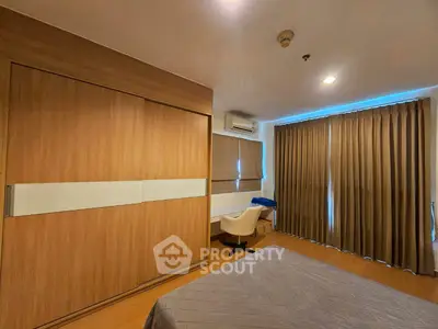 Spacious bedroom with modern design, featuring large windows and ample storage space.