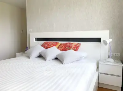 Modern bedroom with stylish decor and comfortable bedding in a contemporary apartment.