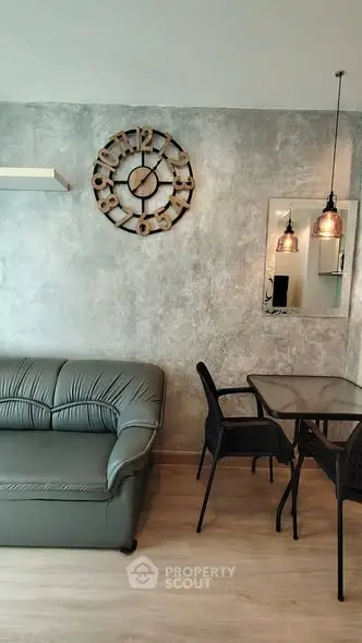 Modern living room with stylish decor and dining area, featuring a unique wall clock and elegant lighting.