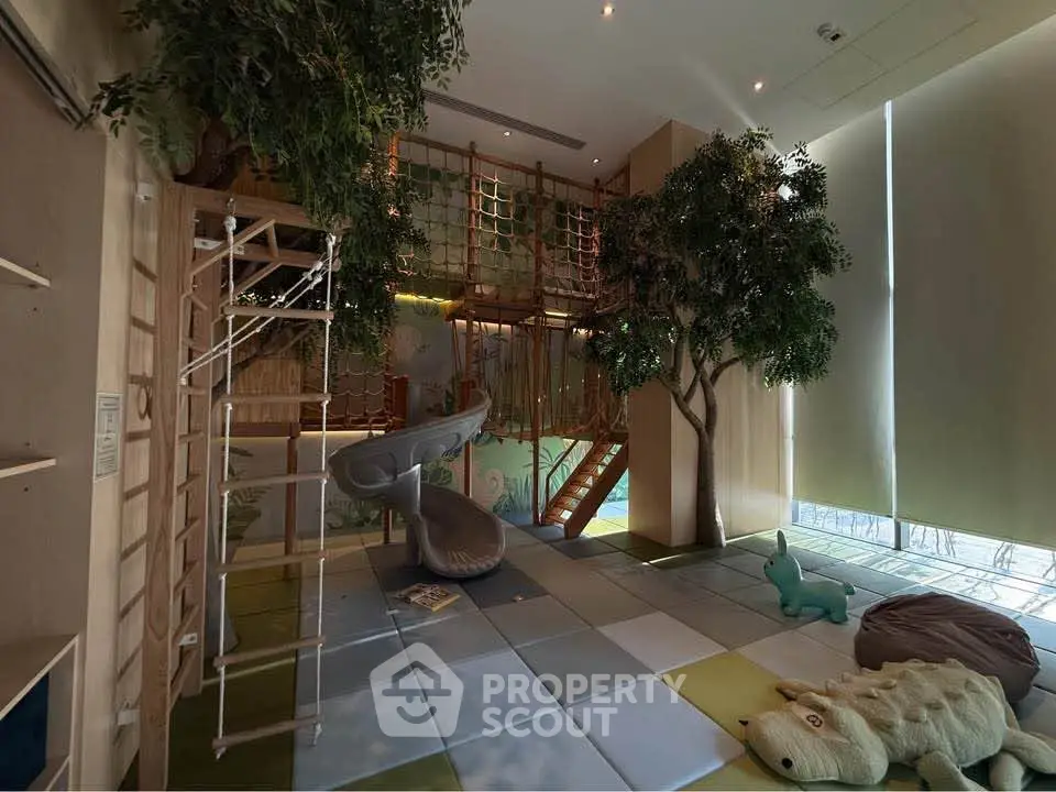 Luxurious indoor play area with climbing structures and slide in modern residential building.