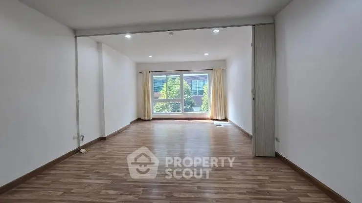 Spacious modern living room with large windows and wooden flooring