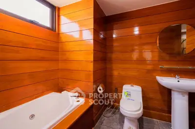 Charming wooden bathroom with bathtub and modern fixtures.