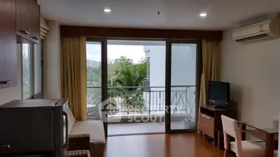 Modern living room with balcony view, featuring sleek furniture and natural light.