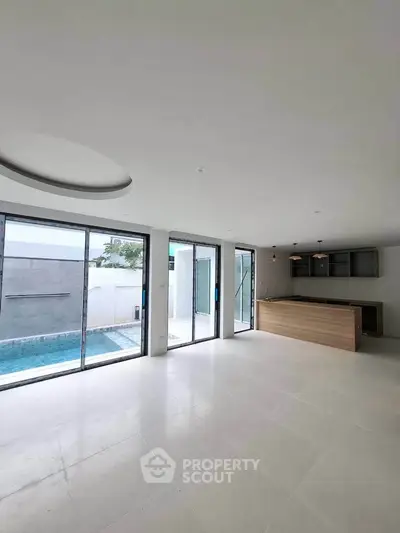 Spacious modern living room with pool view and open kitchen layout