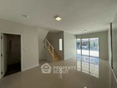 Spacious modern living room with glossy tile flooring and large windows for natural light.