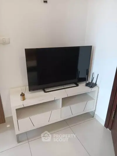 Modern living room with sleek TV stand and flat-screen TV, perfect for entertainment setup.