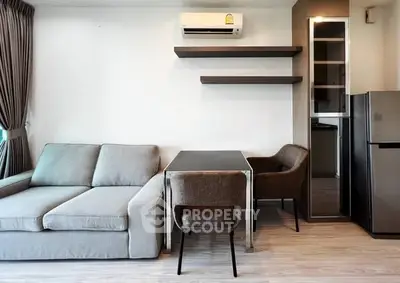 Modern living room with sleek furniture and air conditioning, featuring a cozy sofa and dining area.