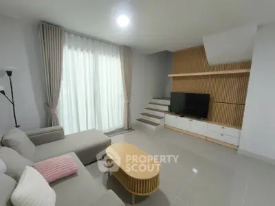 Modern living room with sleek design, featuring a cozy sofa, stylish coffee table, and large TV unit.