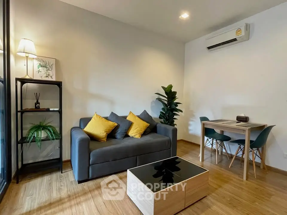 Modern living room with cozy sofa, stylish decor, and dining area in open layout apartment.