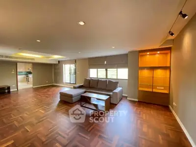 Spacious living room with elegant wood flooring and modern furniture.