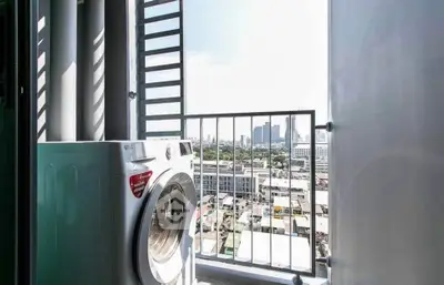 Modern apartment balcony with washing machine and city skyline view, perfect for urban living.