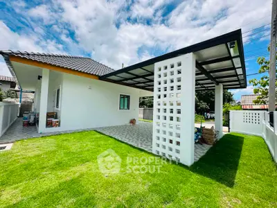 Charming single-story home with modern carport and lush green lawn, perfect for family living.