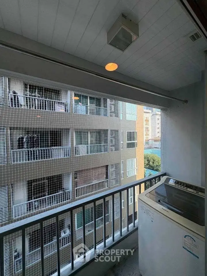 Charming balcony with city view and washing machine, perfect for urban living.