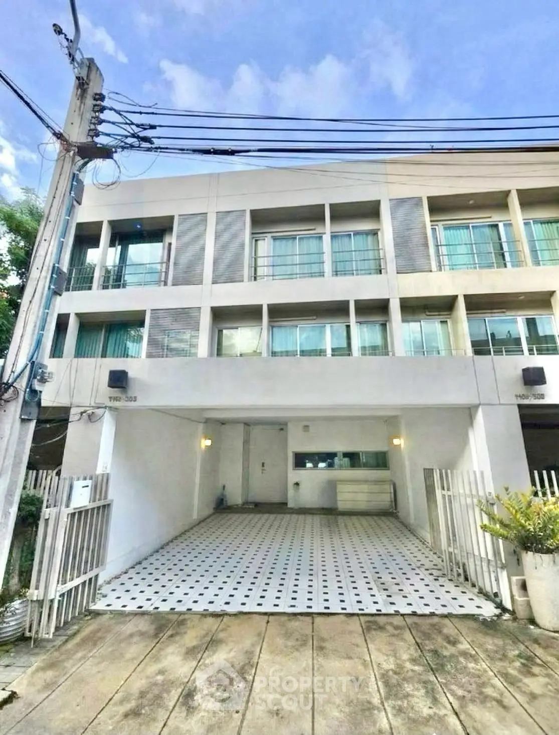 Modern townhouse exterior with spacious driveway and contemporary design.