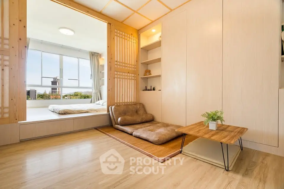 Modern Japanese-style living room with tatami mat and sliding doors, featuring a cozy seating area and natural light.