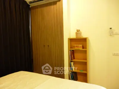 Cozy bedroom with wooden wardrobe and bookshelf, perfect for relaxation and storage.