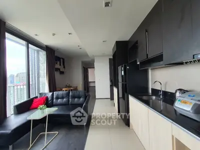 Modern open-layout kitchen and living room with city view, sleek black and wood cabinetry, and stylish furnishings.
