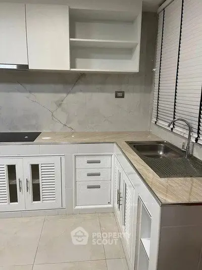 Modern kitchen with sleek white cabinetry and marble countertops